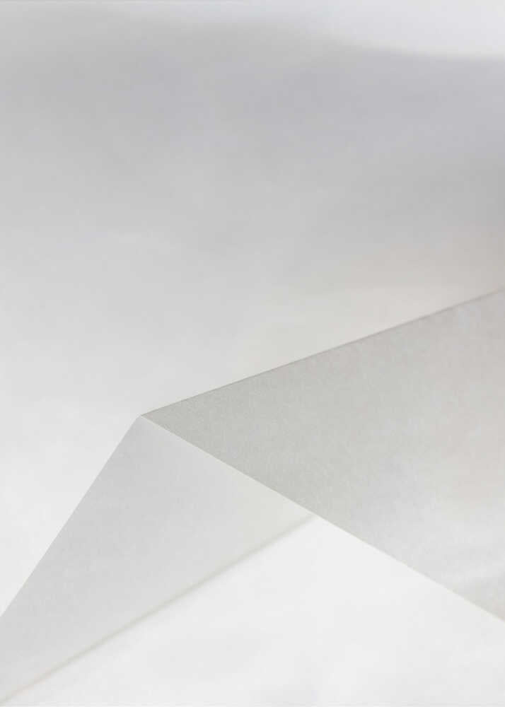 Minimalist abstract art of folded paper creating clean lines and geometric shapes in shades of grey and white.