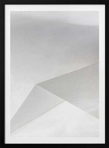 Minimalist abstract art of folded paper creating clean lines and geometric shapes in shades of grey and white.