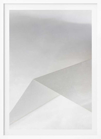 Minimalist abstract art of folded paper creating clean lines and geometric shapes in shades of grey and white.