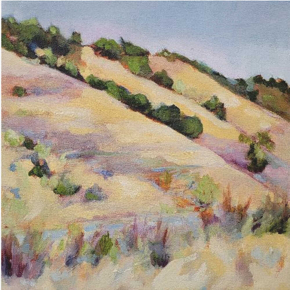 An impressionist oil painting of golden, rolling hills dotted with green shrubs under a pale blue sky, framed in light wood.