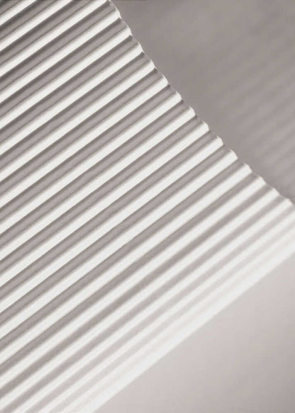 Abstract photograph of a ribbed surface with diagonal lines created by light and shadow, minimalist wall art.