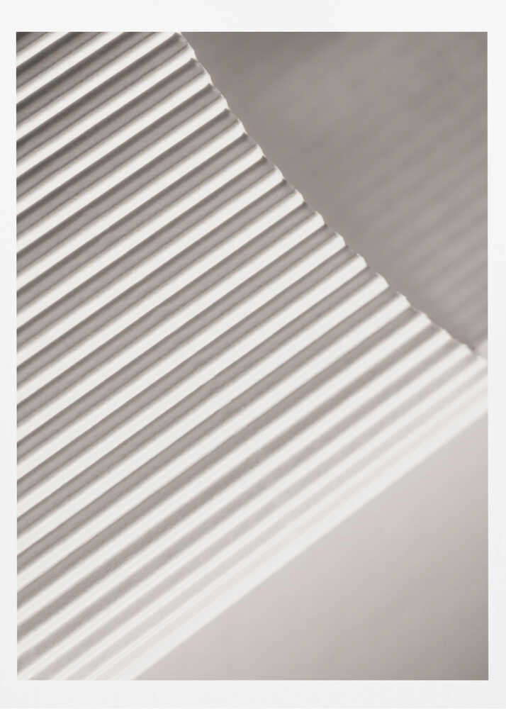 Abstract photograph of a ribbed surface with diagonal lines created by light and shadow, minimalist wall art.