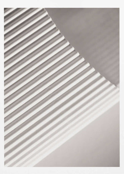 Abstract photograph of a ribbed surface with diagonal lines created by light and shadow, minimalist wall art.