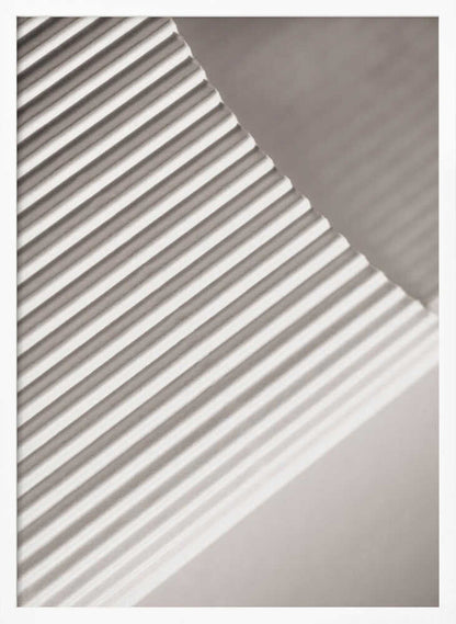 Abstract photograph of a ribbed surface with diagonal lines created by light and shadow, minimalist wall art.