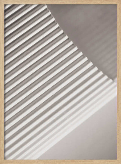 Abstract photograph of a ribbed surface with diagonal lines created by light and shadow, minimalist wall art.