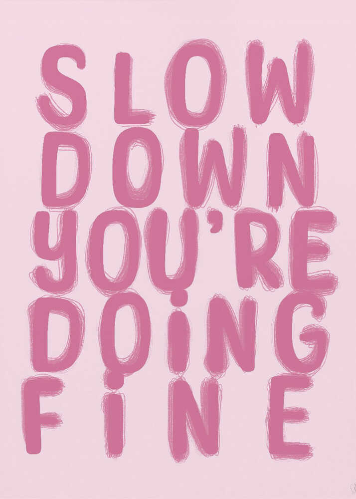A framed art print featuring the phrase 'SLOW DOWN YOU'RE DOING FINE' in a bold, dark pink, brush-stroke font. The words are stacked vertically against a light pink background, all enclosed within a simple black frame. Artwork
