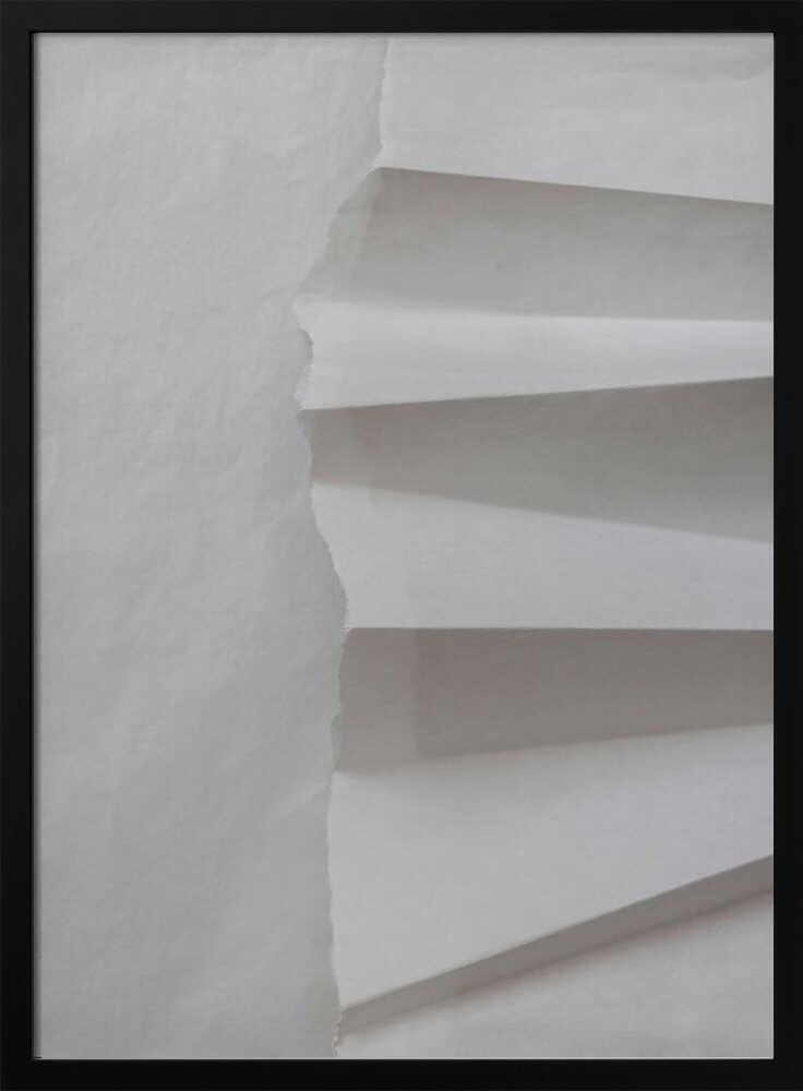 A minimalist composition of folded and torn white paper, showcasing geometric forms and shadows in a black frame.