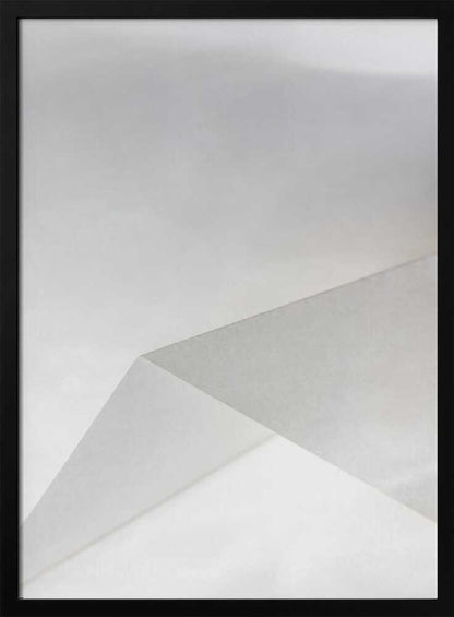 Minimalist abstract art of folded paper creating clean lines and geometric shapes in shades of grey and white.
