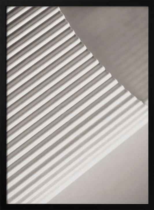 Abstract photograph of a ribbed surface with diagonal lines created by light and shadow, minimalist wall art.