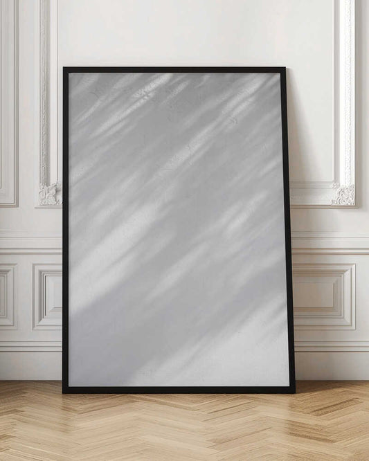 Diagonal leaf shadows cast on a white textured wall, creating a minimalist black and white art piece.