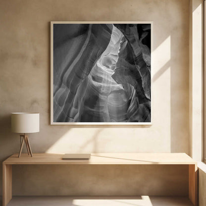 Black and white photo of light in a narrow slot canyon, highlighting smooth, layered rock formations. Nature wall art.